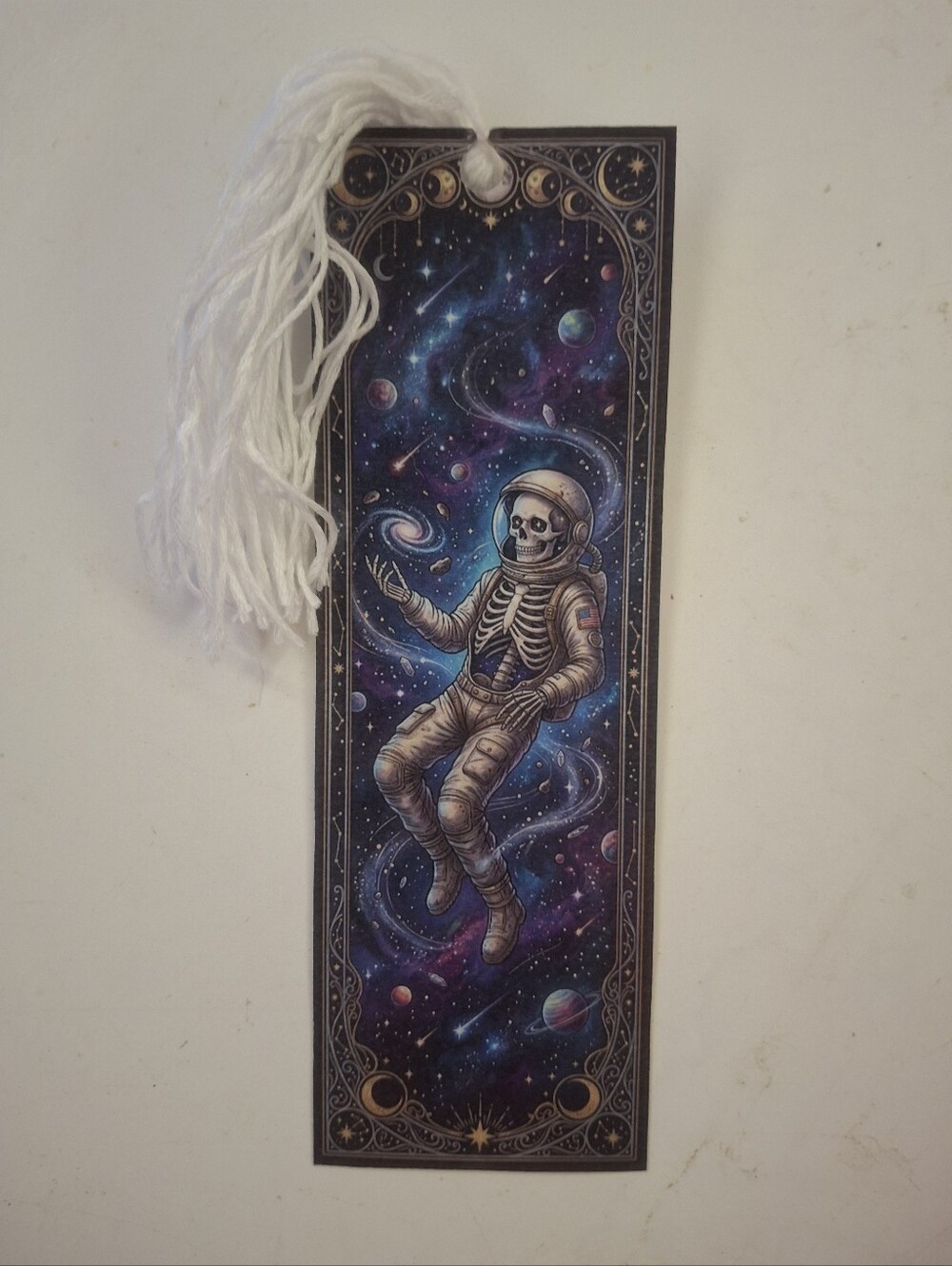 Astronaut skeleton bookmark with tassel Features a skeleton in an astronaut suit